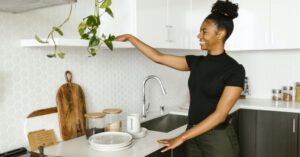 Kitchen Organization - A Smiling Young Woman Organizing her Kitchen