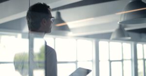 Digital Organization - Formal man with tablet giving presentation in office