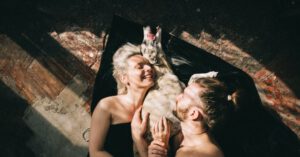 Pets Family - Couple Lying Down and Hugging their Dog