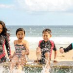 Beach Family - Woman and Three Children Playing Water