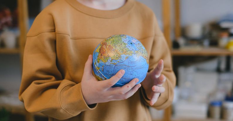 Kids Globe - Person in Brown Long Sleeve Shirt Holding Blue and Green Desk Globe