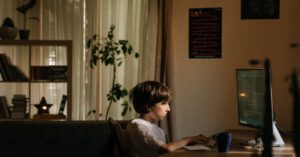 Child Coding - Boy in White Shirt Sitting on Chair