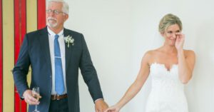 Engaged Parent - Touched bride in white dress holding hands with senior father in elegant suit and wineglass of champagne during wedding day