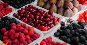 Eco Choices - From above of assorted ripe blackberries figs raspberries and fruits of dog rose at counter