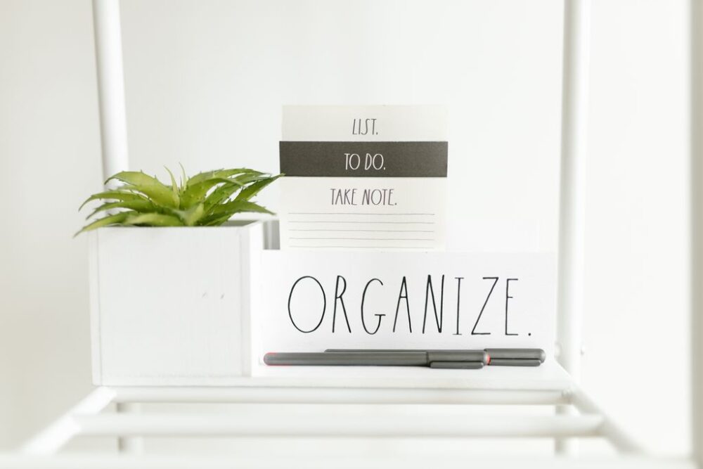 How to Organize a Small Home — A minimalist setup featuring a to-do list, plant, and pens for organized productivity.