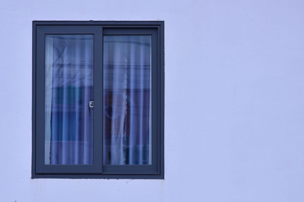 A minimalist view of a modern window with frosted glass on a light blue wall.
