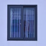A minimalist view of a modern window with frosted glass on a light blue wall.