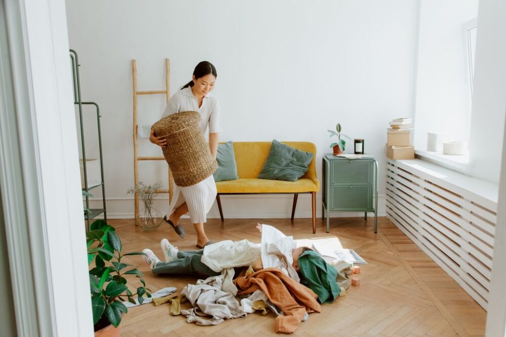 A woman organizing clothes in a cozy living room, creating a tidy and welcoming atmosphere.