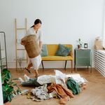 A woman organizing clothes in a cozy living room, creating a tidy and welcoming atmosphere.